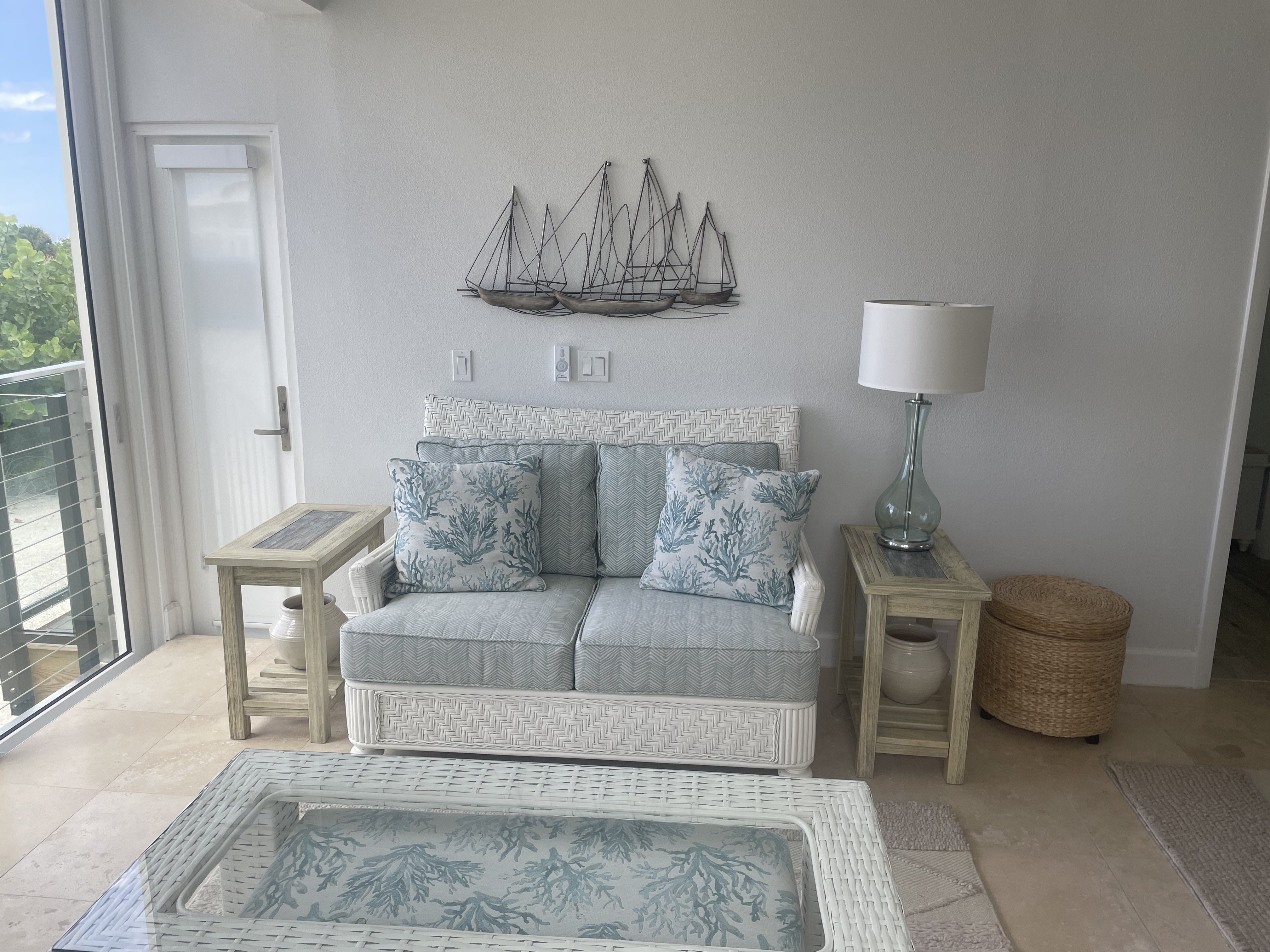 Finished lanai loveseat, side tables, lamp, and sailboat wall art